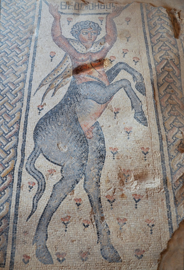 A rearing centaur draped in an animal-skin cloak and holding a bowl in his hands.
